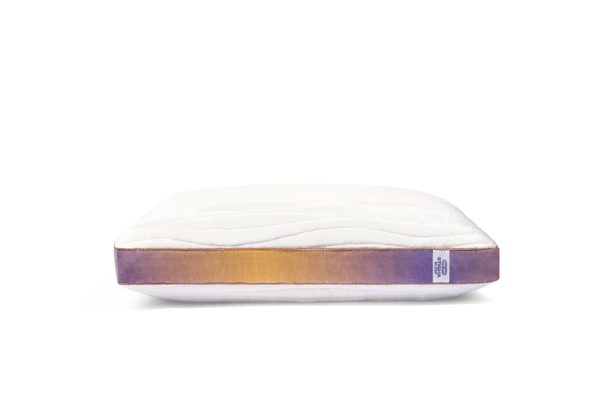 White pillow with gradient purple and orange base on a white background